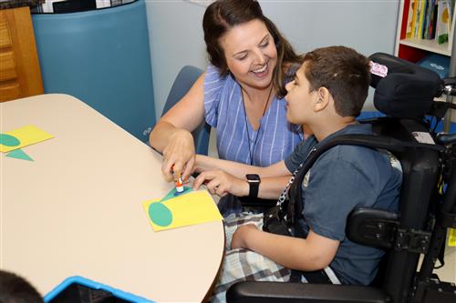 Image of the GCPS Teacher-of-the-Year assisting a student.